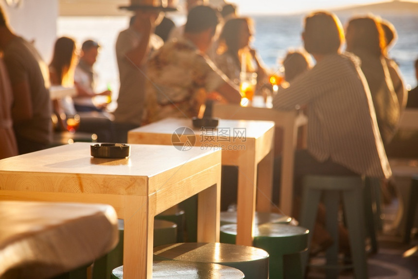海洋日落时在滩边的拥挤餐厅庆典椅子图片