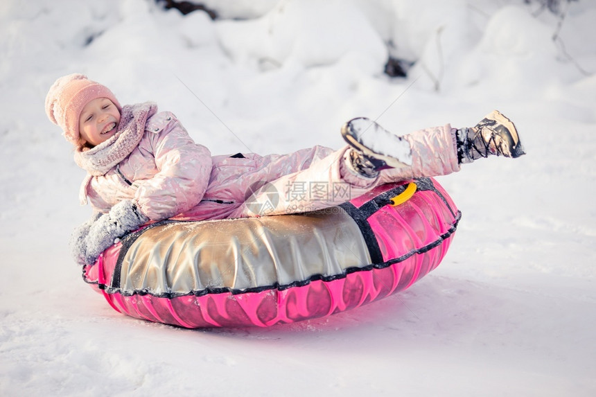 冷冻可爱的孩子在冬日骑着钢管在雪中滑和户外玩在中可喜的快乐小女孩冬季雪上滑一月圣诞节图片