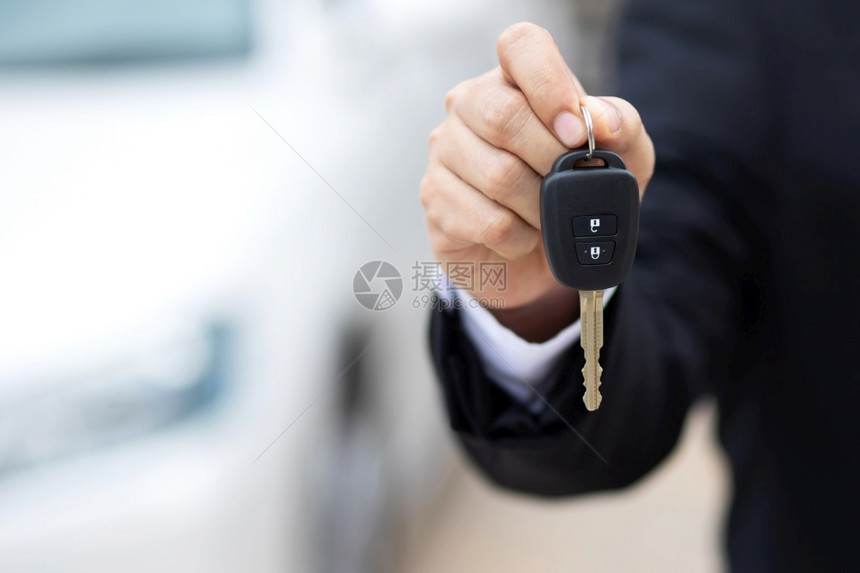 保持服务汽车售员正在把新钥匙送到展厅的顾客手里商业图片