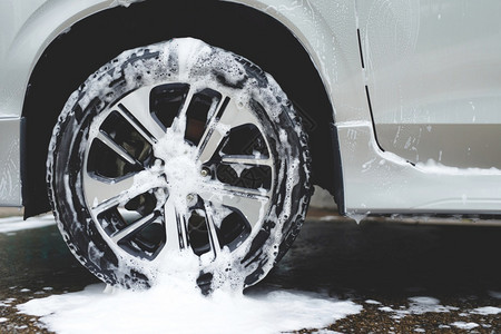 利用活泡沫肥皂清洗车机轮胎商业清洁服务概念车轮洗涤剂闪耀抓住高清图片素材