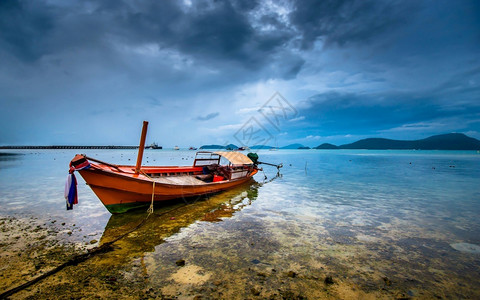 自然传统的绿松石泰国长尾船在气候恶劣的绿水中图片