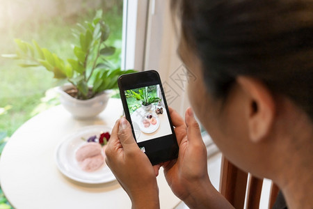监视器女人用智能手机拍甜点的照片水果聪明图片