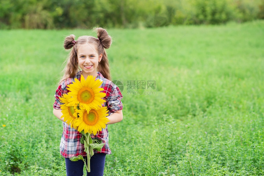 一个穿成格子衬衫的小女孩肖像手上握着一束向日葵花在背景上画着一个小女孩的肖像手里拿着大漂亮的向日葵花束祝贺橙景观图片