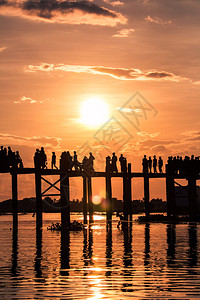 湖日落时分在UBein桥上行走的人休光片柚木金子图片