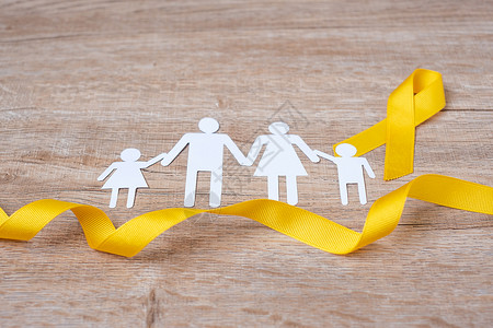 儿家庭幸存者预防和儿童癌症意识黄丝带和家庭纸型以支持人们生活和患病儿童保健世界癌症日概念健康护理和世界癌症日概念支持人们的健康和疾病儿背景