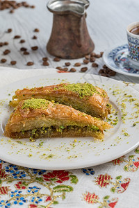 木桌上的土耳其咖啡和传统土耳其甜点果仁蜜饼土耳其咖啡和木桌上的传统土耳其甜点榛子喜盘美食高清图片素材