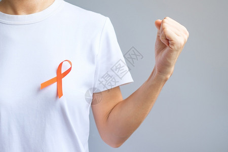 佩戴橙丝带的男人预防癌症概念图片