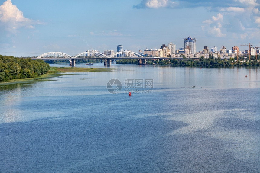 浮地上宽阔的Dnipro河水面沉入岸绿一条白色铁路桥和地平线上的基辅新住宅区并复制空间海岸地平线上的Dnipro铁路桥和基辅新住图片