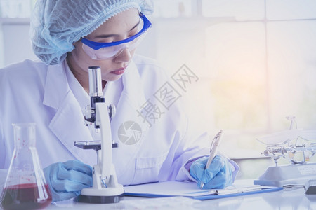 女科学家使用显微镜进行化学实验研究图片