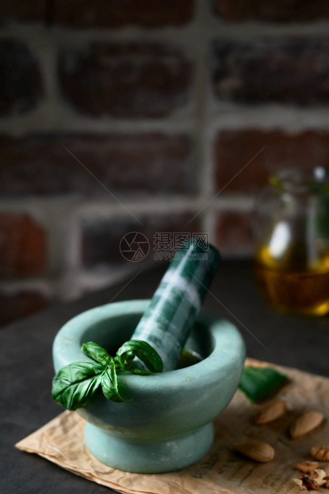 准备灰色的草本集中关注在火厨房中的巴西尔叶橄榄油坚果核仁面包和木制桌上的香料以近距离关闭图片