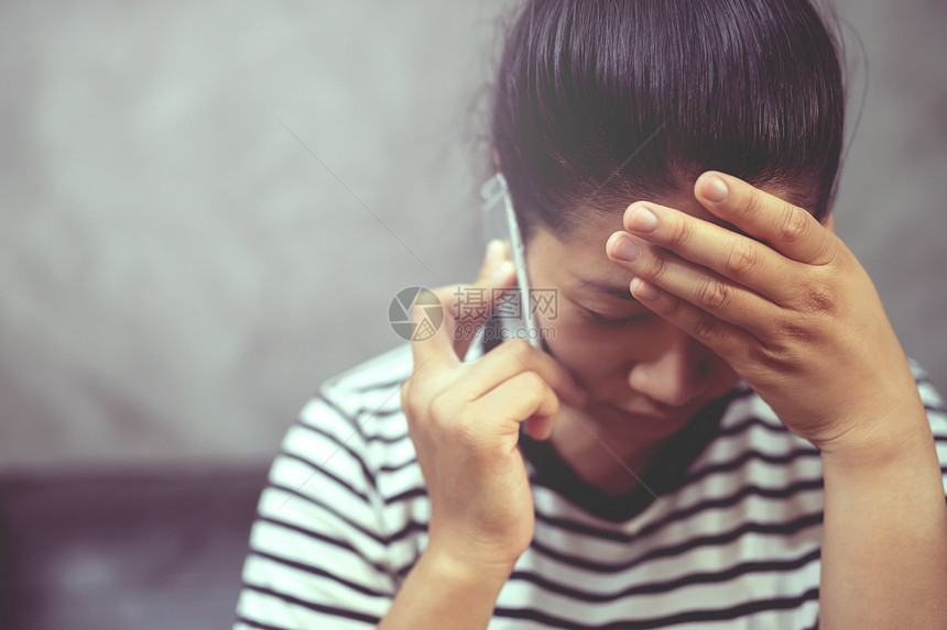 绝望的脸女人和男朋友在电话上聊天她后悔跟男朋友分手了她很后悔挫折