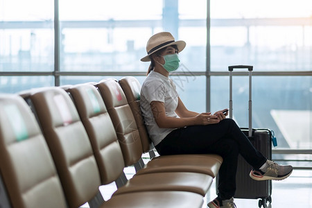 戴着口罩在机场等候登机的游客图片