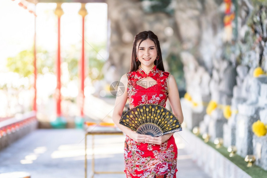 时尚可爱的美丽亚洲年轻女子身着传统红青山装饰在泰国华神庙举办中新年节盛会的风向节日活动校对Portnoy图片
