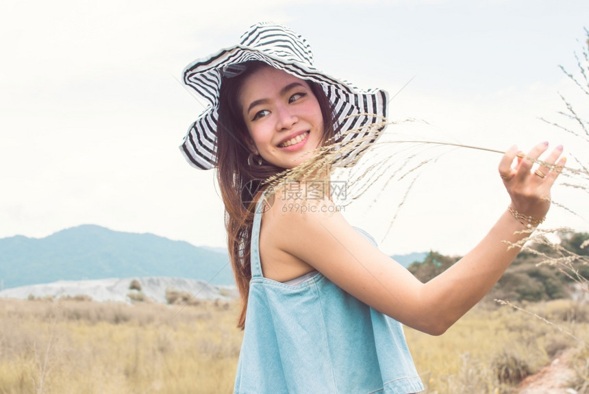 景观旅游身戴帽子和夏季旅行的美丽亚洲妇女其背景为模糊的山峰和蓝天空力量图片