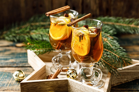 卡尤加县新年冬季假日和圣诞节的热饮加柠檬卡多姆肉桂和三丁香辣椒茶和朗姆酒鸡尾格罗庆典冷杉背景