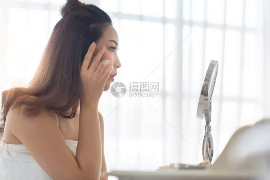 美貌女孩在化妆和触摸脸容的漂亮女孩年轻美丽的亚洲女人在镜中的Acne穿着皮肤美容学护理美容疗漂亮的水分过敏图片