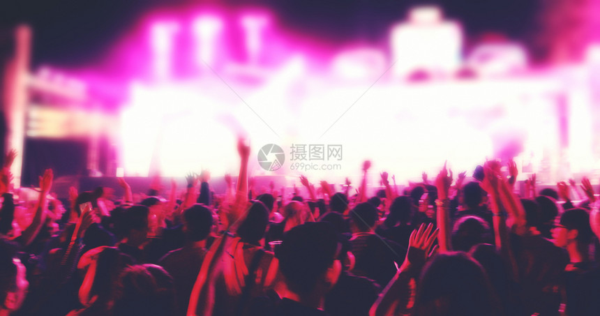 拍明亮的舞台灯下举起手来在音乐会观众看节日人群的后视线上幸福声音图片