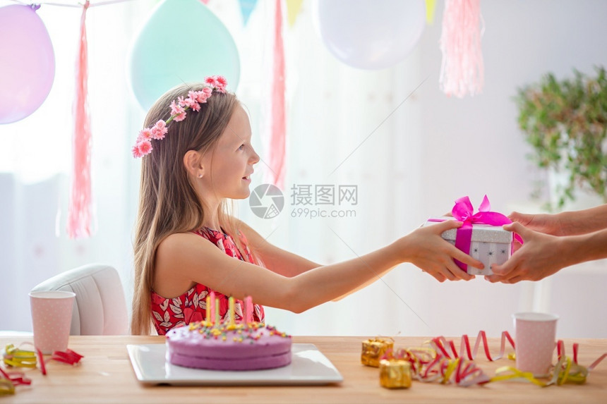 孩子蜡烛快乐的小女孩在生日派对上微笑快乐的小女孩在生日派对上笑与气球生日派对一起充满多彩背景希望概念高加索女孩满怀梦想地微笑并看图片