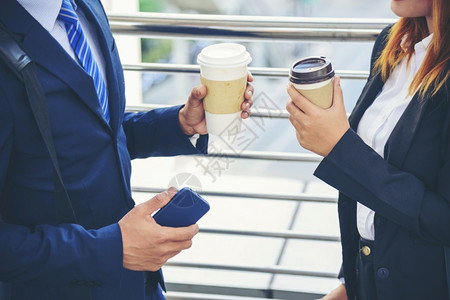 真正的商界女人在办公室外的镇子喝咖啡现代城市手举拿掉咖啡杯一起聊天愉快伙伴生意人正式西装加一杯咖啡正式的约会优雅高清图片素材