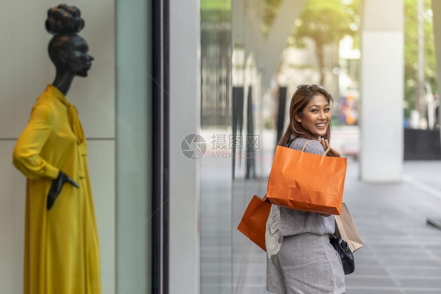 中央亚洲妇女漫步在商店旁购物在省中心采取快乐的行动生活方式时尚和休闲销售黑色周日概念等生活方式和休闲销售消费主义购买图片