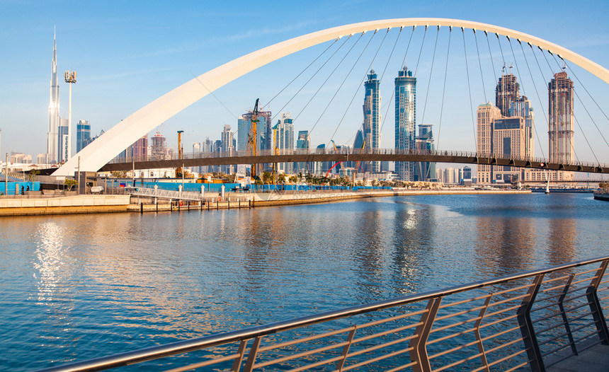 迪拜市中心摩天大楼和新建的容忍桥上从迪拜水渠中可以看出日落是多彩的世界阿拉伯未来派图片