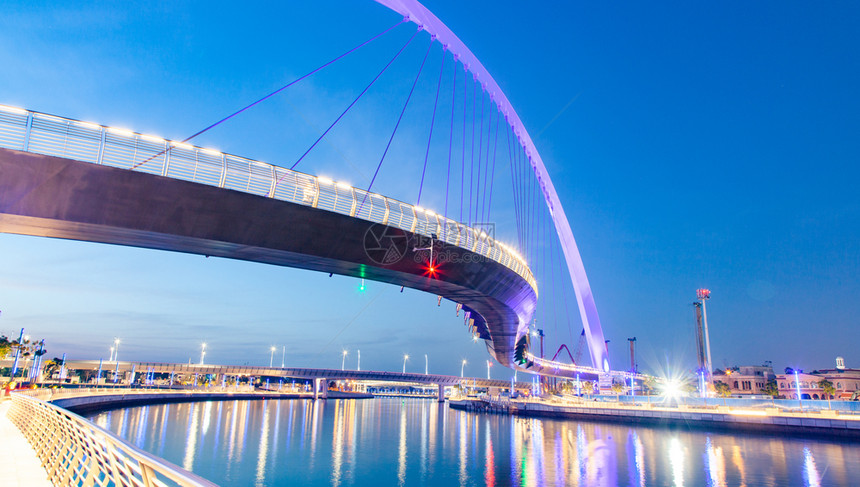 天际线迪拜市中心摩天大楼和新建的容忍桥上从迪拜水渠中可以看出日落是多彩的阿联酋夜晚图片