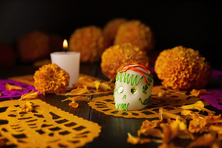 或者庆典花朵墨西哥纪念死者节的祭坛上通常使用的糖头盖骨蜡烛Cempasuchil花或Marigold和PapelPicado装饰背景图片