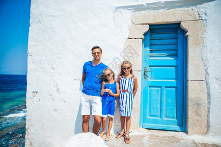 孩子们观看城市景欧洲家庭度假父亲和孩子背景是希腊Mykonos镇的Mykonos镇在Mykonos岛户外玩乐的家庭传统的高清图片素材