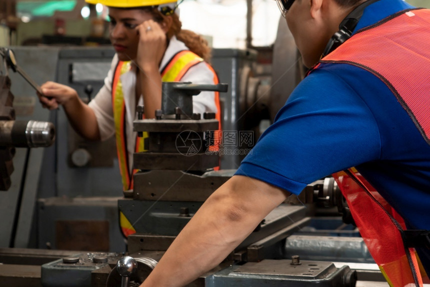 车床行业紧迫在工厂车间使用机器设备的熟练工人组业和程员技术概念在工厂车间使用机器设备的熟练工人组图片