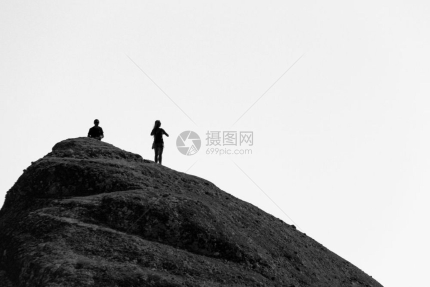 单色戏剧山希腊Meteora修道院建筑群的岩石顶上有男人和女的轮光影图片