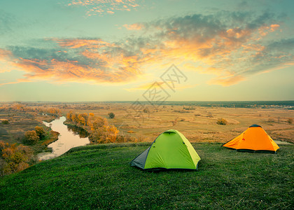 河岸边的绿色和橙帐篷野营图片