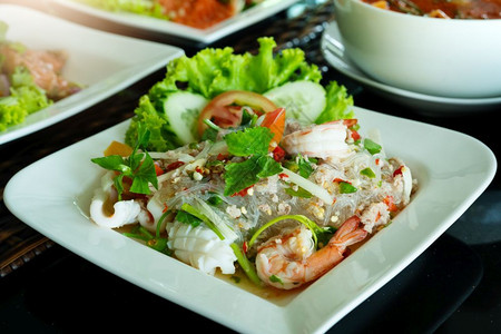 斯派西面沙拉香辣的马铃薯沙拉和新鲜虾鱿鱼泰国食品风格大蒜开胃菜午餐图片