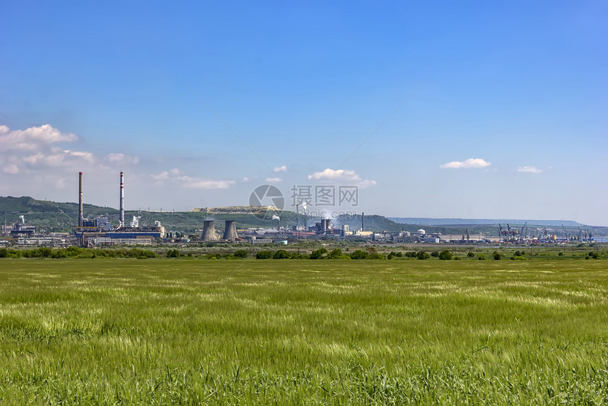 在一片绿稻田中间的一个工厂天景下植物井水管静地污染空气绿色行业草地图片