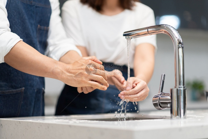 身体亚洲夫妇在家做饭前先用泡沫肥皂洗手男人和女清洁在厨房卫生中用水槽清洗指甲和手防止冠状腺保护常设图片