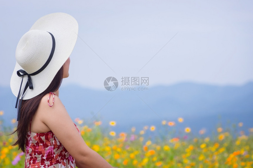 天空女身着自然花的美丽女子她穿着白色礼服和红帽子在泰国兰芒省MaeMohCoalMine的TungBuaTong墨西哥向日葵田上图片