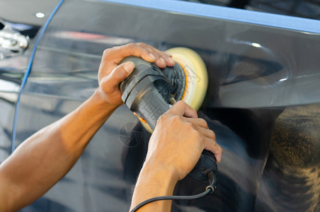 负责打磨涂层汽车擦面的男子在车面后会帮助消除车面表的污染物在擦车面之后将发光关心工人服务图片