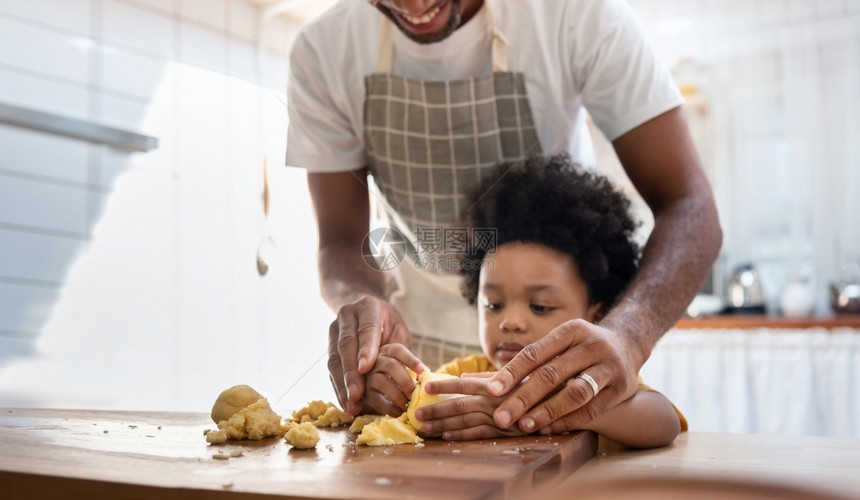 面粉黑人家庭有乐趣黑人家庭有乐趣在中准备面包店在非裔美国人的父亲和可爱儿子在厨房里玩小甜点快乐的爱人和小帮手男孩在做蛋糕和饼干时图片