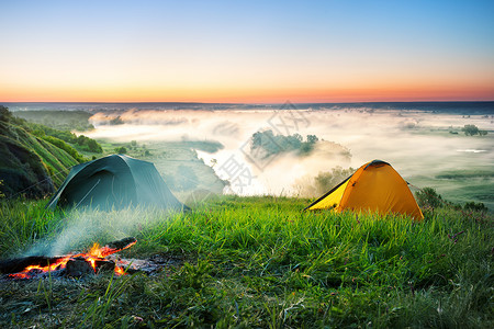 清晨在山上露营水雾河边的山上露营背景图片