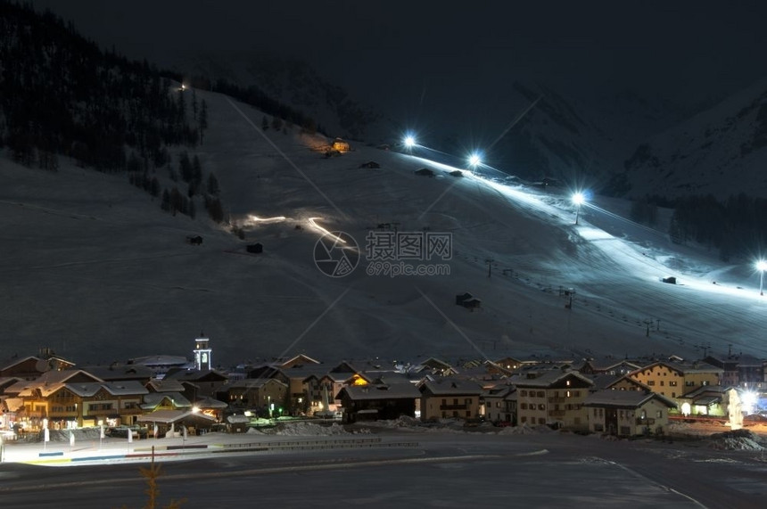 夜间有斜坡灯的Ski村跨国滑雪跑车建筑物冰纪念碑在意大利阿尔卑斯山维诺拍摄小屋点亮季节图片