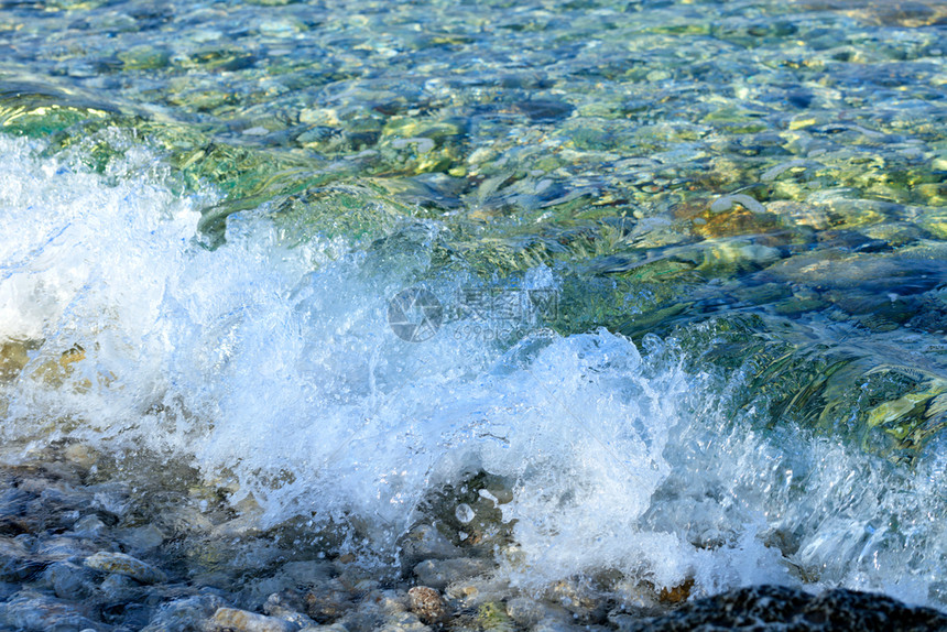 湿的海湾美丽浪在一片卵石海滩上加透明绿宝石泡沫的美丽海浪以复制空间为图象A纯绿宝石海浪喷洒在岸的碎石上风图片