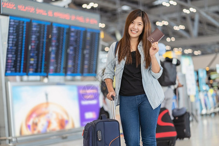 在现代机场飞行信息屏幕上登机旅行和具有技术概念的运输等现代机场旅行和运输时有护照的亚洲旅行者在飞板上站立着检查行李的肖像木板团体家庭高清图片素材