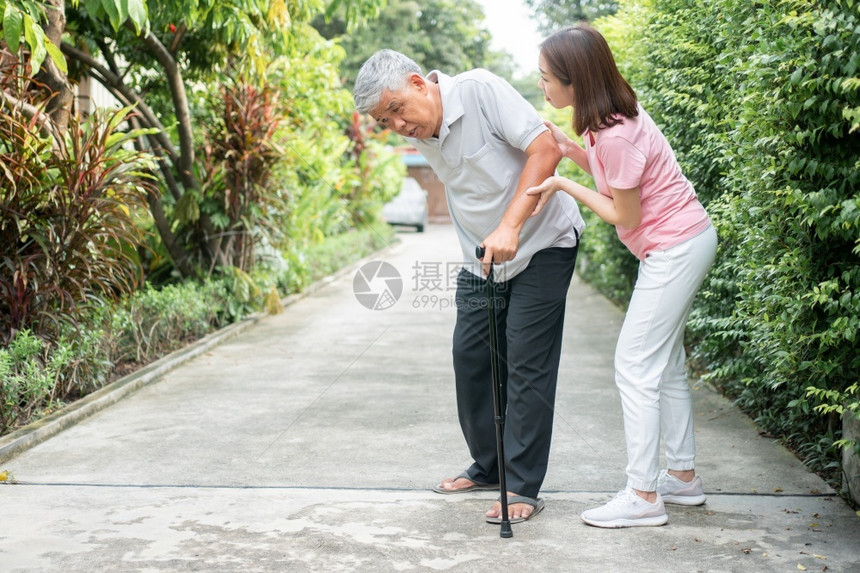 女儿帮老年母亲在公园里走路图片