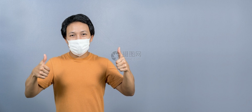 卫生健康恐慌身戴外科口罩的亚洲人肖像手举大拇指如蓝色背景科罗纳流行共生19年爆发社会动荡与责任保健和护等图片