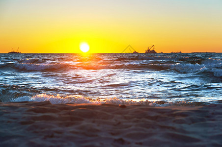 云天气在波罗的海浪冲和辉煌日出时海边的红黄夕阳钻机图片