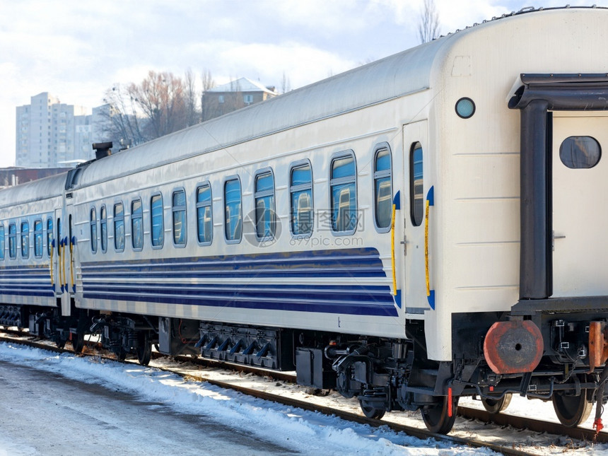 窗户机壳城际一辆白色火车蓝条纹的白铁路车站在轨上阳光明媚的冬季日晴朗天火车白色铁路站在轨上图片