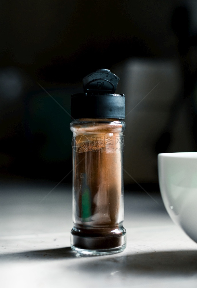 在一个小玻璃瓶和白碗中的咖啡粉即时用一个小玻璃瓶和白色碗装成泡沫Dalgona咖啡在家厨房的准备时间黑暗瓶子白色图片