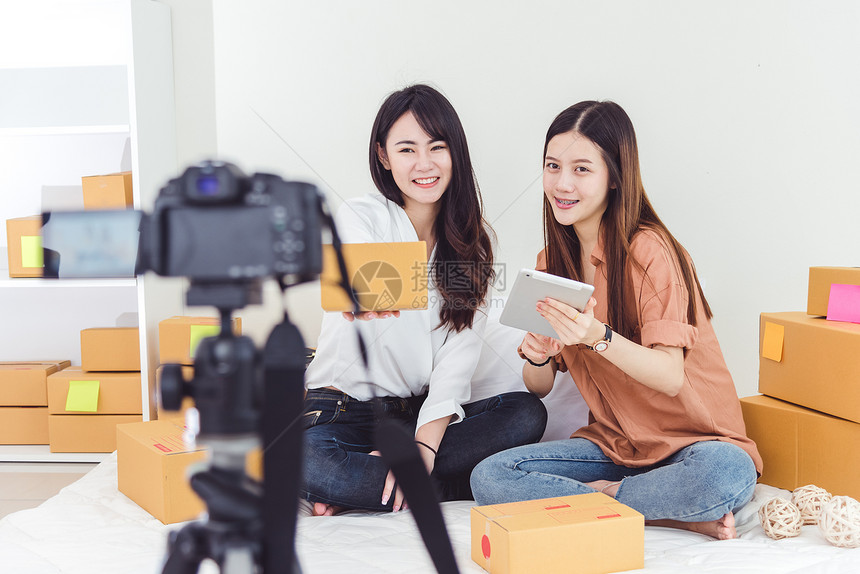 两名亚洲妇女使用数码摄像机录制和展示新的产品广告Vlog和影响力人概念并用数字录像机制和推出新的产品广告从事兼职工作和技术职业的图片