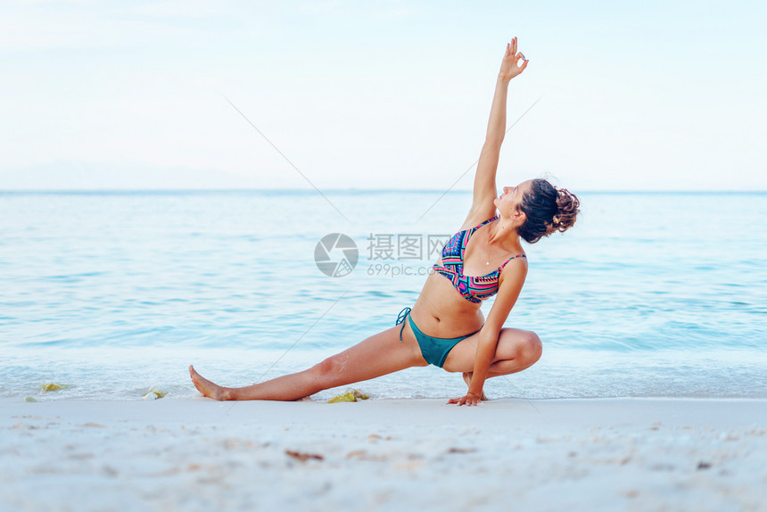 请享用灵冷静的年轻漂亮黑人女孩在夏天比基尼泳衣练瑜伽的女孩比基尼泳衣在海边滩上做瑜伽在阳光明媚的假期里图片