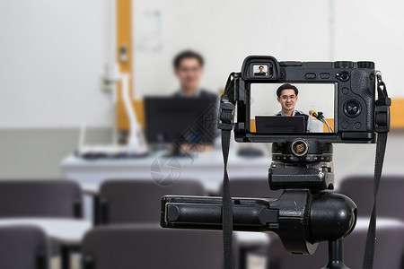 沟通笔记本电脑年轻的在课堂上亚洲教师三脚架录制视频博客上的专业数字无镜化相机摄影师或录像与技术现场流概念摄影像馆大学教育校内电视演讲高清图片素材