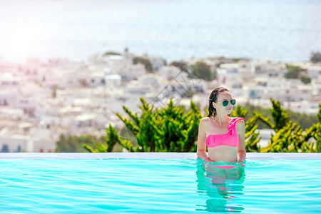 轮廓假期年轻美女享受豪华安静的游泳池年轻美女在室外豪华游泳池享受暑假日光浴闲暇高清图片素材